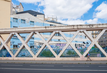 Paris, France - August 8, 2018: Man walking along a bridge on rue Lafayette, above the railways of gare de l'Estのeditorial素材