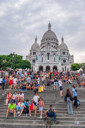 Paris, France - August 7, 2018: Tourists on the steps to the church of Sacre-Coeur in Montmartre in Paris, France on a hot even if cloudy summer afternoon.のeditorial素材