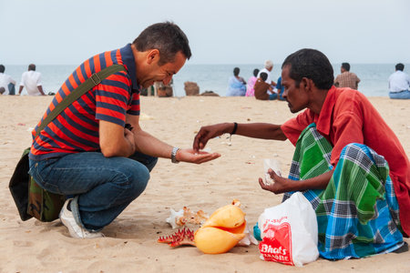 Chennai, India - September 6, 2007: A tourist buys coral pearls from a local seller at the popular...