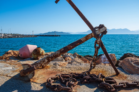 Rusty anchor on the shore at Aegina island harbour in Greeceの写真素材