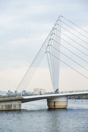 Manchester, United Kingdom - April 24, 2019: Modern suspended bridge at the Salford Quays on the banks of the Manchester Ship Canal in Salford and Trafford, Greater Manchesterのeditorial素材