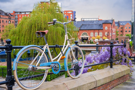Manchester, United Kingdom - April 25, 2019: Atmospheric scene  of a parked bicycle at the restored Victorian canal system in Castlefield area of Manchesterのeditorial素材