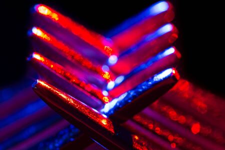 Two forks in colorful illumination macro shot creating an abstract composition. Image is suitable as...