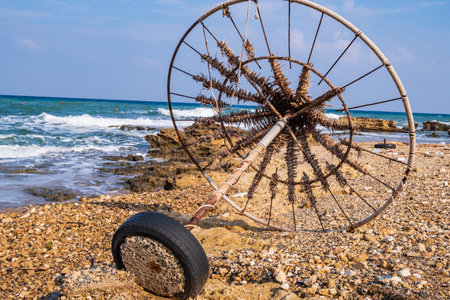 Abandoned beach umbrella on a rocky beach set against the sea. Taken ona beach in Protaras, Cyprus.の写真素材