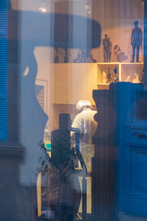 Nicosia, Cyprus - December 9, 2020: View form the outside of a window of an artist's workshop in old Nicosia with the artist in the background.のeditorial素材