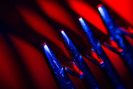 Two forks in colorful illumination macro shot creating an abstract composition. Image is suitable as a background.の写真素材