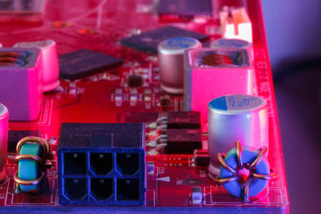 Electronic Printed Circuit Board with Electronic components in red viewed form above and sideways
