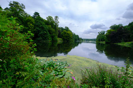 Beautiful landscape comprising trees foliage and the Fish Pond  in the area of the Harewood House Trust in West Yorkshire in the United Kingdomの写真素材