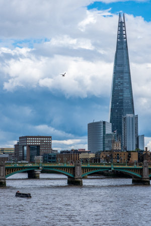 The Shard skyscraper landmark building dominating the skyline behind the Southwark Bridge over river Thames.のeditorial素材