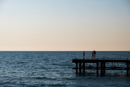 Silhouettes of people on a derelict pier in Argaka in Cyprus.の写真素材