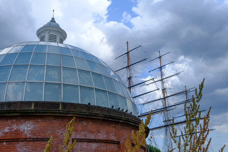 Greenwich Foot Tunnel entrance and the masts of the Cutty Sark in Greenwich, London in the UK