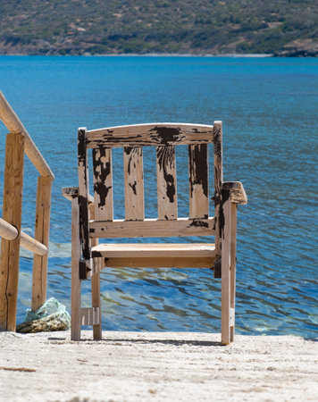 Wooden chair overlooking the blue sea at Pomos harbor, island of Cyprusの写真素材