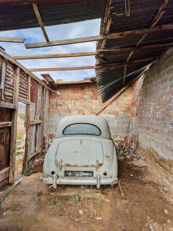 Rusty old vintage car in an abandoned garage of a countryside houseの写真素材