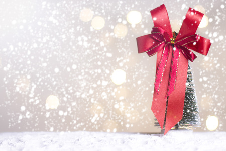 Miniature Christmas Santa cros and Tree on snow over blurred bokeh background,Decoration Image for Christmas Holiday and Happy New Year Gift box Celebration concept.の写真素材