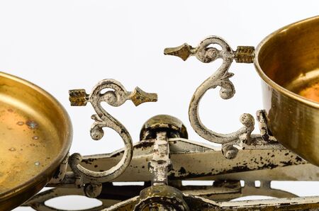 Detail of an old pair of scales not in balance beam scale white backgroundの写真素材