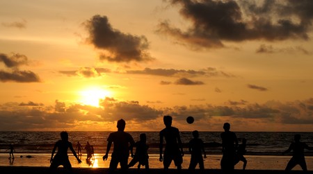Football playing during sunsetの写真素材