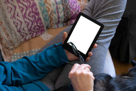 Woman reading on an electronic reading device at homeのeditorial素材