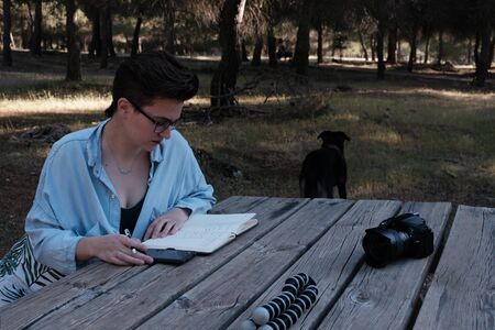 Young womand and youtuber plans what she's going to say in her video on a notebook.の写真素材