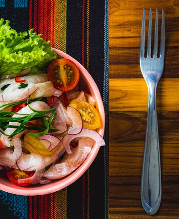 overhead view of a plate of ceviche on a colorful tableclothの写真素材