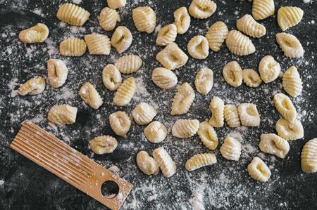 homemade potato gnocchis handmade with flour and egg on a black tableの写真素材