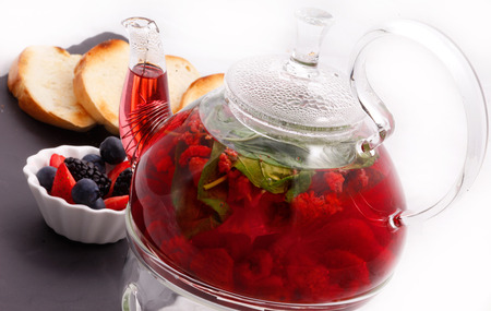 Berry tea with glass teapot and toastの写真素材