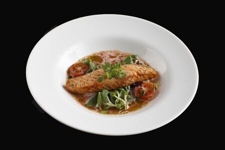salmon steak with greens and sauceの写真素材