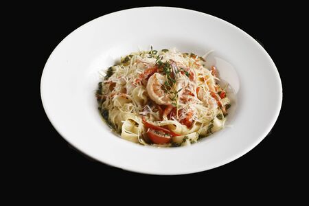 pasta in cream sauce with king prawns on a plateの写真素材