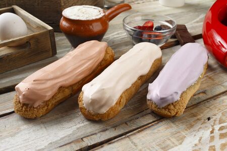 eclairs with different fillings on wooden backgroundの写真素材