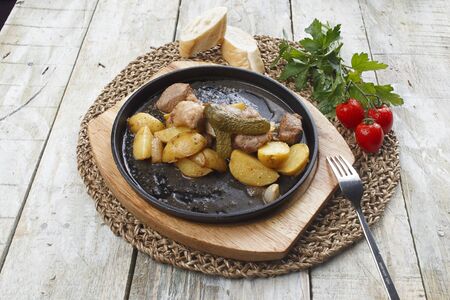 Spicy fried potatoes with herbs and spices served in white plate.の写真素材