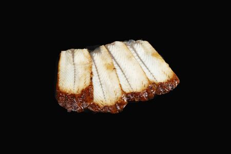 sliced â€‹â€‹smoked eel on black background