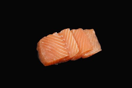 sliced ââraw salmon on black backgroundの写真素材