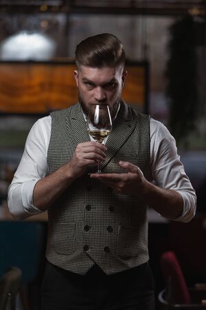 Professional sommelier man with a glass of white wine. selective focusの写真素材