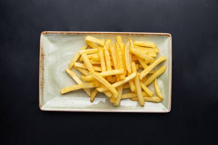 french fries in a plate on a dark backgroundの写真素材