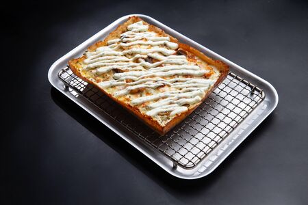 detroit pizza on an iron tray on a dark background. selective focusの写真素材
