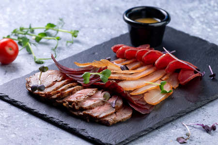 Assorted dry-cured meats on a stone background. selective focusの写真素材