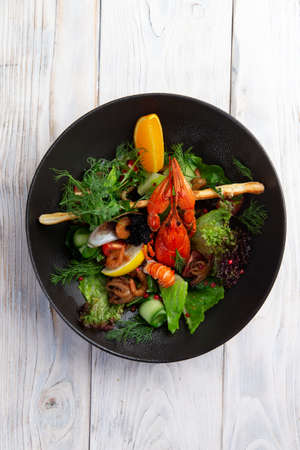 Salad with seafood in a dark plate. selective focusの写真素材