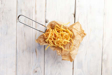 Beer snack. Deep-fried onions. On a light background