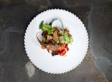 Seafood salad in a plate. On a stone background. Selective focusの写真素材