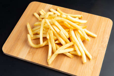 French fries on the board. on a dark background