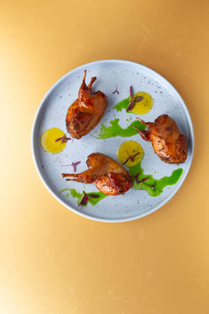 Fried quails in a plate on a yellow background. View from above.の写真素材
