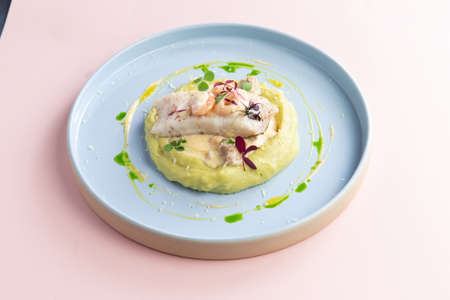 Fillet of white fish on a pillow of mashed potatoes. in a plate on a light background.の写真素材