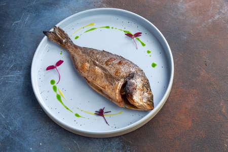 Fried dorado fish in a plate. Selective focusの写真素材