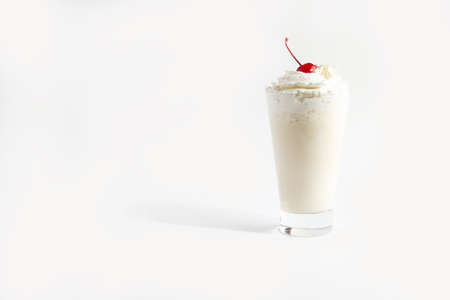 Milkshake in a glass with whipped cream and cherries. isolated on white background