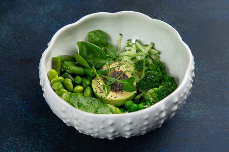 Poke with avacado, herbs and beans in a plate. Against a dark background. Selective focus.の写真素材