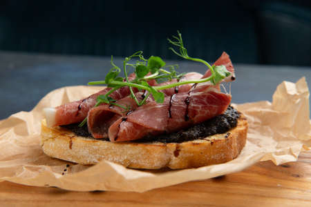 bruschetta with jamon and herbs. Against a dark background. Selective focus.の写真素材
