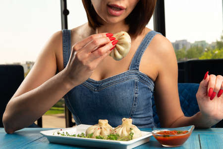 The hand holds the national dish khinkali. selective focusの写真素材