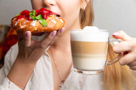 Girl with coffee and strawberry dessert. Selective focus.