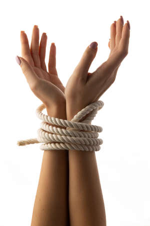 Tied female hands isolated on white background.の写真素材