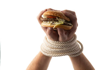Tied hands are holding a burger. isolated on white background.の写真素材