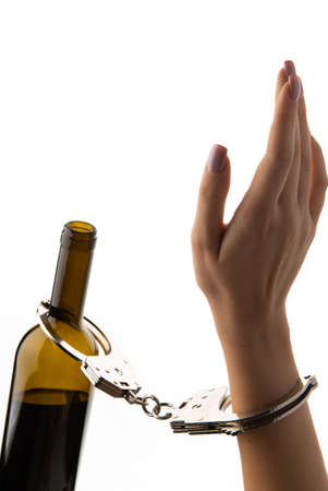 Hands chained to a bottle of alcohol. isolated on white background.の写真素材